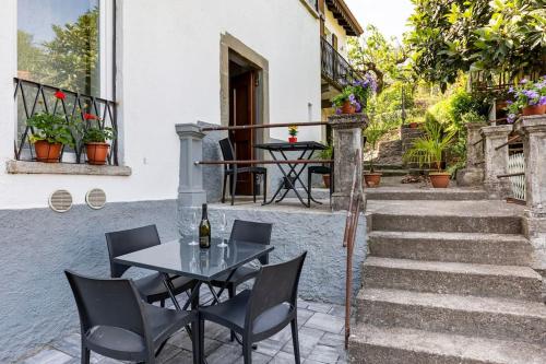a table and chairs on a patio with stairs at Clelia's Apartment (Como) in Como