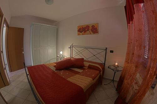 a bedroom with a bed with a red comforter at Agriturismo La Fattoria in Norcia