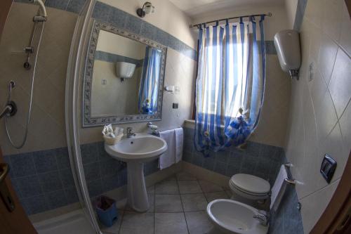 a bathroom with a sink and a toilet and a mirror at Agriturismo La Fattoria in Norcia