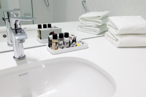a bathroom counter with a sink and towels at Hotel Lis Baixa in Lisbon