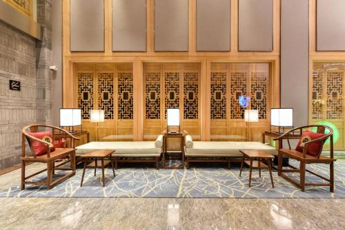 a room with two chairs and a table with a couch at Atour Hotel South Luogu Lane Beijing in Beijing