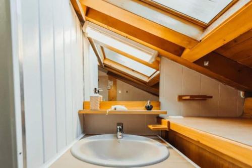 a bathroom with a white sink and a skylight at Cocon familial proche télécabine in Saint-Gervais-les-Bains