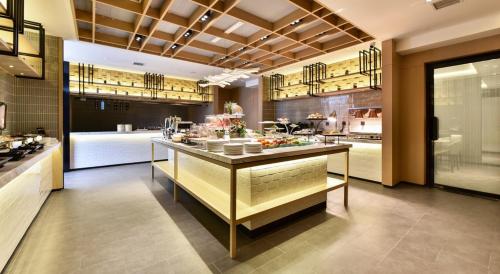 una cucina con bancone e cibo di Atour Hotel Dalian Development Zone Jinma Road a Dalian