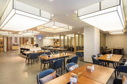 a restaurant with wooden tables and chairs and lights at Atour Hotel Shenzhen Nanshan Qianhai Yiche in Shenzhen