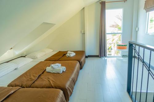 a bedroom with two beds with towels on them at Apinya Resort Bangsarey in Ban Tao Than
