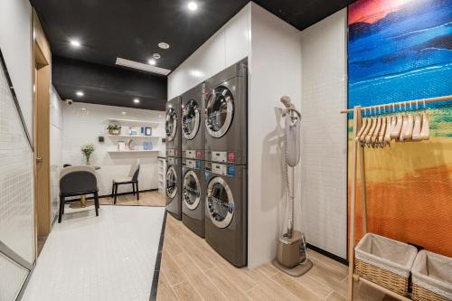 a laundry room with three washer and dryer at Atour Hotel Suzhou Guanqian Street in Suzhou