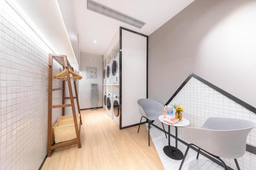 a laundry room with a ladder and a table at Atour Hotel Suzhou Guanqian Street Leqiao Station in Suzhou