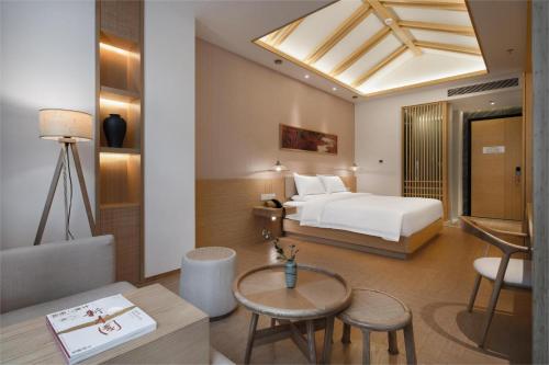 une chambre d'hôtel avec un lit et une table dans l'établissement Atour X Hotel Shenzhen Futian CBD Chegongmiao, à Shenzhen