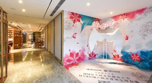 a hallway with a wall with a mural of a chicken at Atour Hotel South Luogu Lane Beijing in Beijing