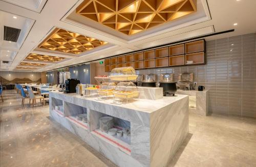 a restaurant with a counter with food on it at Atour Hotel Changsha International Covention Centre South Railway Station in Changsha