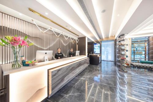 two women sitting at a counter in a hotel lobby at Atour Hotel Suzhou Guanqian Street Leqiao Station in Suzhou