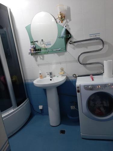 een badkamer met een wastafel en een wasmachine bij Квартира в Гюмри in Gjoemri