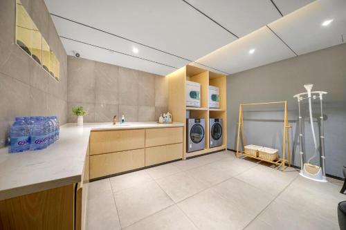 哈爾濱的住宿－哈尔滨高铁西站亚朵X酒店，洗衣房配有水槽和2台洗衣机