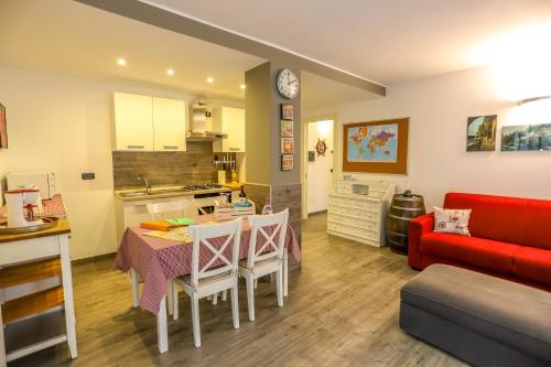 a kitchen and living room with a table and a red couch at Tizi House in Varenna