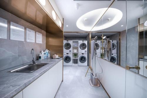 a laundry room with a sink and washing machines at Atour Light Hotel Guangzhou Zhujiang New Town Wuyangtun in Guangzhou