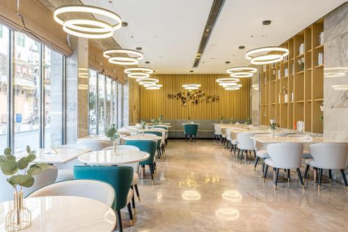 een restaurant met witte tafels, stoelen en ramen bij Atour X Hotel Xiamen Zhongshan Road Ferry Wharf in Xiamen