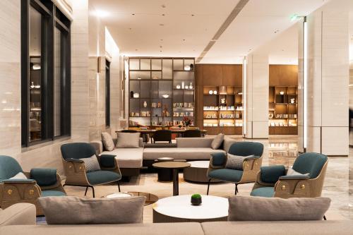 大連市にあるAtour Hotel Dalian Development Zoneのホテルのロビー(ソファテーブル、椅子付)