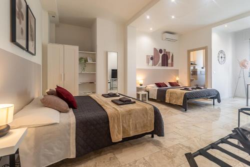 a bedroom with two beds and a living room at Bologna Bed Station in Bologna