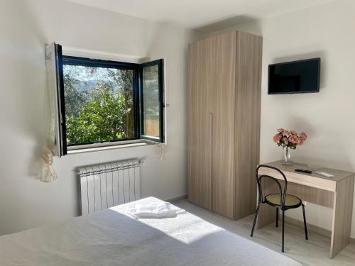 1 dormitorio con cama, escritorio y ventana en Sorrento Realty Holidays - The smile of the sun, en Sorrento