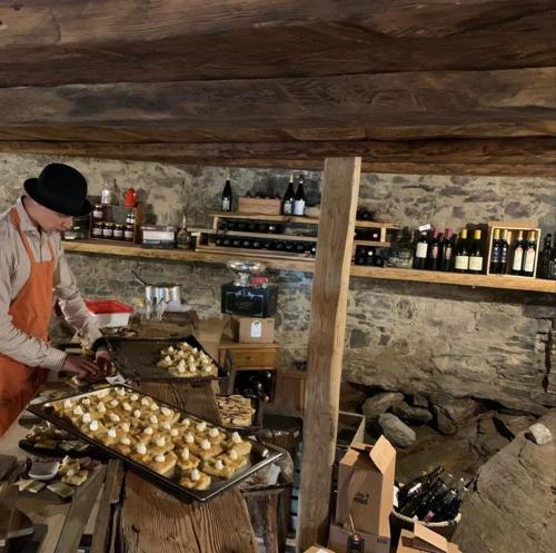 a man standing in a kitchen preparing food at Chalet del Lago in Ceresole Reale