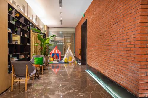 a room with a red brick wall and chairs at Atour Hotel Shanghai Lujiazui Babaiban in Shanghai