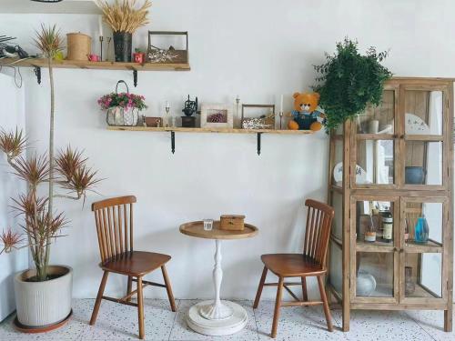 a table and two chairs in a room with shelves at Encounter Garden Great Wall Holiday Guesthouse in Beijing