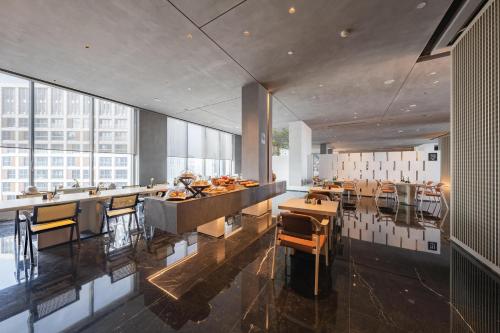 una cocina con mesas y sillas en un edificio en Atour S Hotel Shanghai Lujiazui Expo Center, en Shanghái