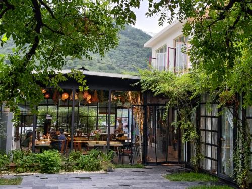 a restaurant with glass doors and a table at Encounter Garden Great Wall Holiday Guesthouse in Beijing