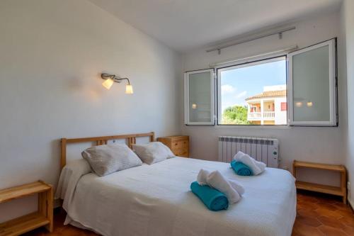a bedroom with two beds and a window at Can Joan in Santanyi