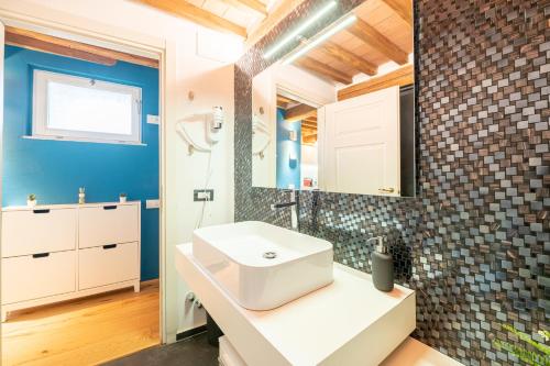 een badkamer met een witte wastafel en een spiegel bij CASA SAN PAOLINO [Dentro le mura]Elegant Flat WIFI e SelfCheckin in Lucca