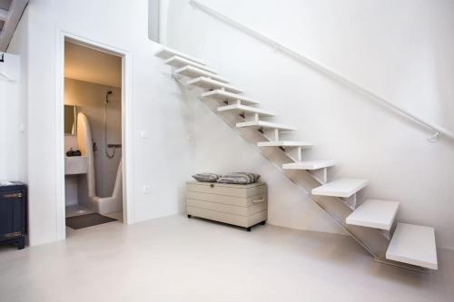 a staircase in a white room with a bathroom at Hidden Gem Authentic cycladic house in Paros in Márpissa