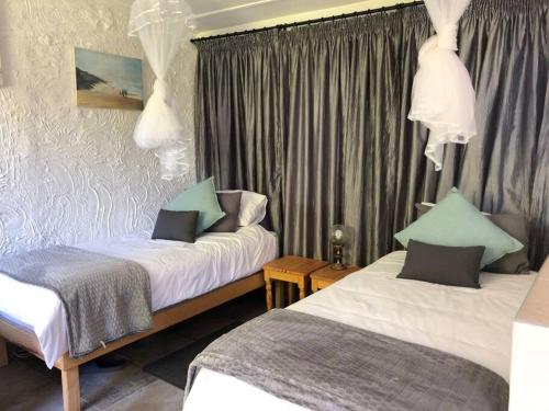 a hotel room with two beds and curtains at Roberto's in Hilton