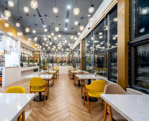 a dining room with tables and yellow chairs at Atour Hotel Shanghai Lujiazui Minsheng Road Station in Shanghai