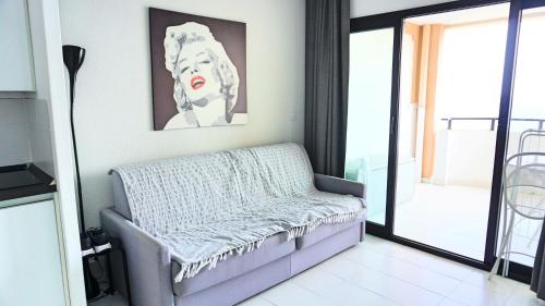 un soggiorno con panchina e una foto appesa al muro di Appartement 753, 4 personnes, vue mer By Palmazur a Cannes