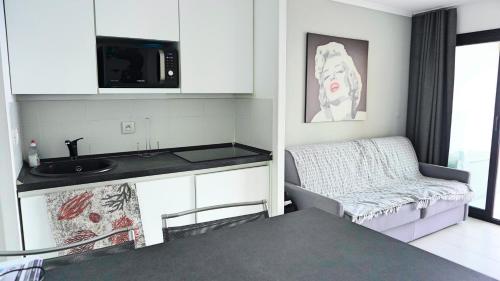 a small kitchen with a sink and a couch at Appartement 753, 4 personnes, vue mer By Palmazur in Cannes