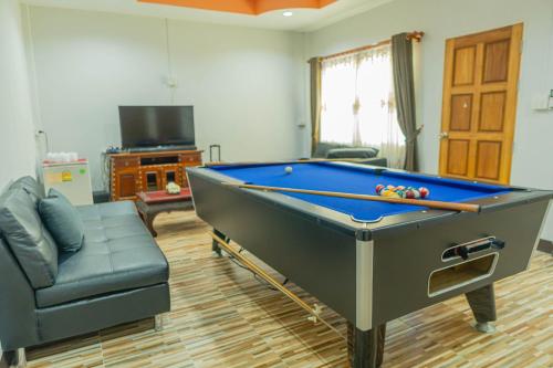 a living room with a pool table and a couch at Apinya Resort Bangsarey in Ban Tao Than