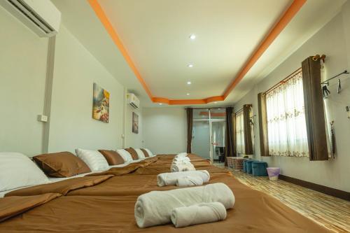 a large bed with four pillows on it in a room at Apinya Resort Bangsarey in Ban Tao Than