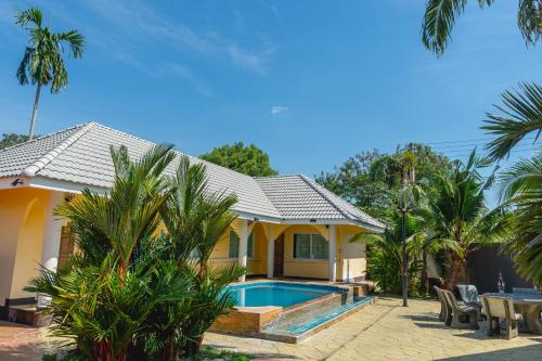a house with a swimming pool in front of it at Apinya Resort Bangsarey in Ban Tao Than
