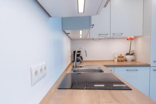a kitchen with white cabinets and a sink at Zum Lindenwirt - Al Tiglio in Naz-Sciaves