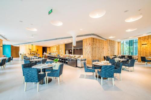 a restaurant with blue chairs and tables and a counter at Atour S Hotel Binhe Times Shenzhen in Shenzhen