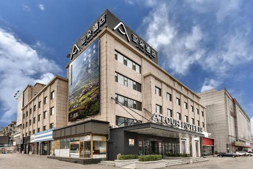 a building with a sign on the side of it at Atour Hotel Dalian Development Zone Jinma Road in Dalian