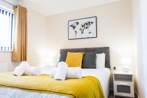 um quarto com uma cama grande e um cobertor amarelo em Penny's Place em Plymouth