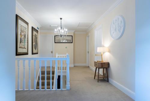 a room with a crib and a clock on the wall at Charnwood Guest House in Bracknell