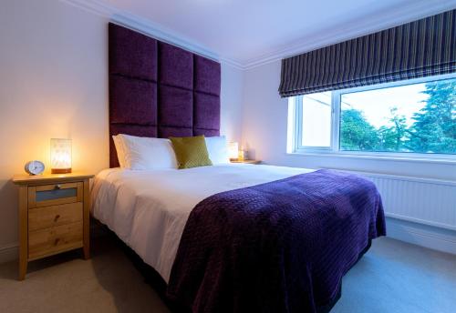 a bedroom with a large bed and a window at Charnwood Guest House in Bracknell