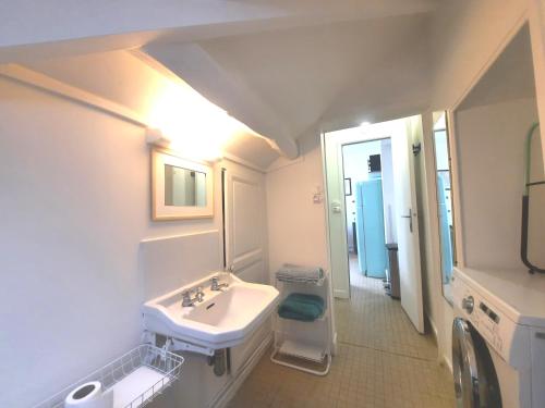 a white bathroom with a sink and a mirror at La Seine, entre rivière et forêt de Fontainebleau in Bois-le-Roi