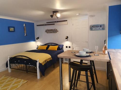 a bedroom with a bed and a table with a dining room at Hayling Hideaway, private cosy annex near to beach in South Hayling