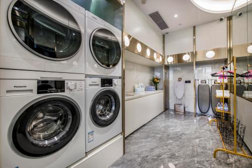 a laundry room with three washing machines in it at Atour Hotel Zhuhai Gongbei Port Fuhuali CBD in Zhuhai
