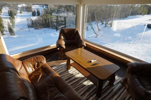 a living room with couches and a table and a large window at Kütioru puhkekeskus in Koloreino