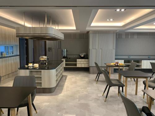 cocina grande y comedor con mesas y sillas en Thana Wisut Hotel - SHA Plus, en Bangkok