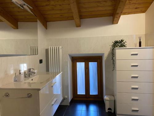 baño con lavabo, armario y puerta en LAKE HOUSE near Bellagio, en Lezzeno
